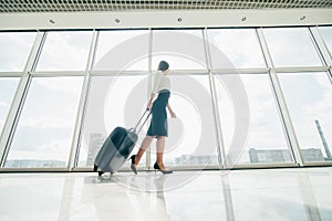 Business woman with laggage bag walking in airport to gate