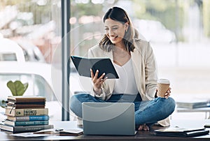 Business woman, laptop or reading notebook while sitting on desk in marketing office, advertising company or creative