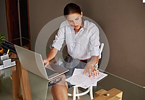 Business woman, laptop and remote work with paperwork, finance and invoice or accounting. Financial clerk, tax audit and