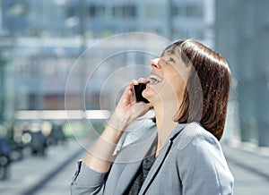 Business woman laughing and talking on cell phone