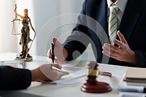 Business woman and lawyers discussing contract papers with brass scale on wooden desk in office. Law, legal services