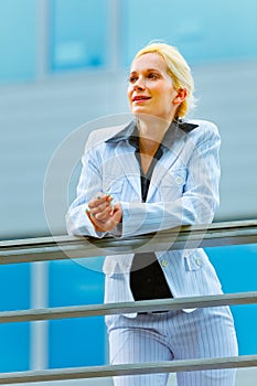 Business woman leaning on railing at office