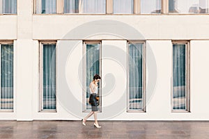 Business woman in leather skirt talking on the phone while walki