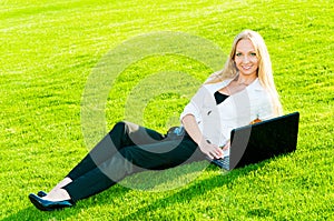 Business woman lies on the grass