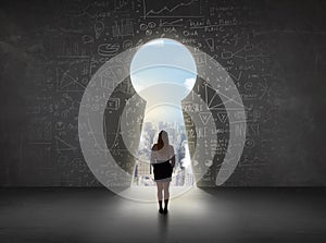 Business woman looking at keyhole with bright cityscape concept photo