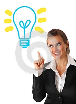 Business woman looking at lamp with rised finger photo