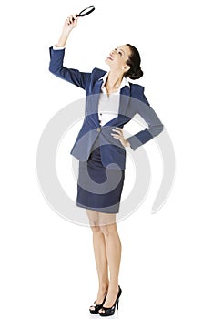 Business woman looking into a magnifying glass