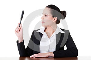 Business woman looking through magnifying glass.