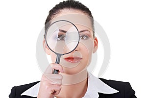 Business woman looking through magnifying glass.
