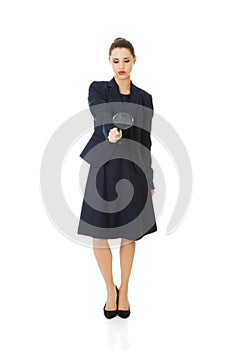 Business woman looking into a magnifying glass