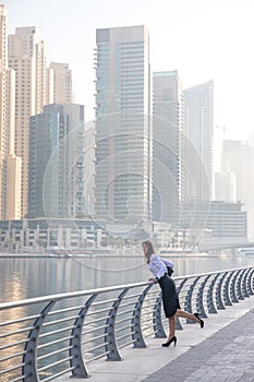 Business woman looking over the side of a boardwalk.