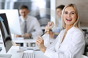 Business woman looks happy and excited at workplace in modern office. Secretary or female lawyer working for pleasure