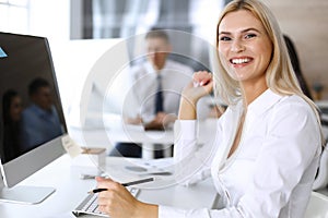 Business woman looks happy and excited at workplace in modern office. Secretary or female lawyer working for pleasure