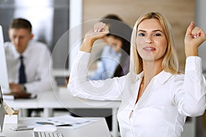 Business woman looks happy and excited at workplace in modern office. Secretary or female lawyer working for pleasure