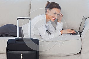 Business woman lying on couch and looking at camera