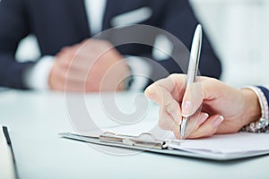 Business woman making notes at office workplace.