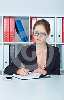 Business woman in glasses making notes at office workplace. Business job offer, financial success, certified public