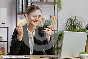 Business woman making online purchase payment shopping with credit bank card and laptop at office