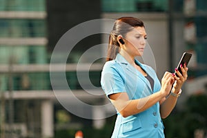 Business woman making a phone call with bluetooth device