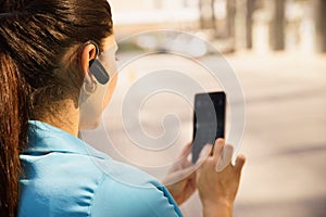 Business woman making a phone call with bluetooth device