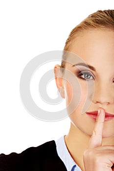 Business woman making silent sign with finger on lips