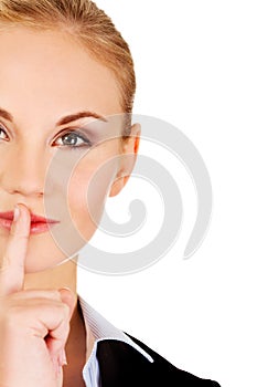 Business woman making silent sign with finger on lips