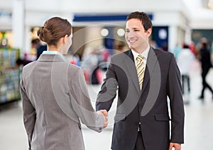 business woman and man handshake. shopping centre