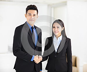 Business woman and man handshaking in office