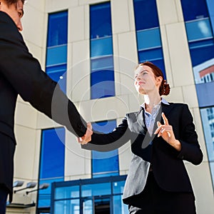 Business woman and man shaking hands outdoors. Business cooperation concept