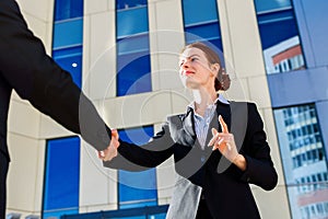 Business woman and man shaking hands outdoors. Business cooperation concept