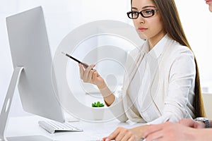 Business woman and man sitting and working with computer and calculator in office. Bookkeeper or accountant checking