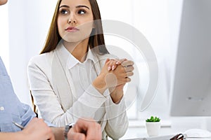 Business woman and man sitting and working with computer in office. Colleagues discussing something at meeting