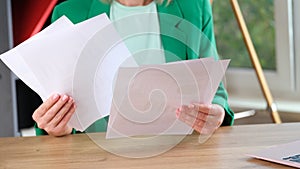 Business woman with many financial documents in hands at office desk.