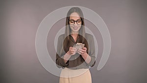 Business woman middleweight woman on isolated yellow background scrolls internet. Woman in a business green shirt and