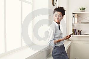 Business woman with mobile phone near office window