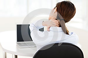 Business woman with neck ache in office