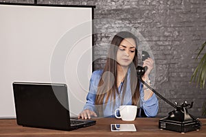 Business woman is negotiating with a landline phone