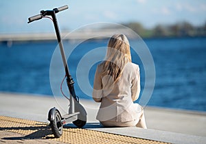 Business woman next to electric scooter