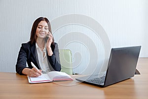 Business woman with notebook, calendar and mobile phone at work.