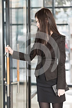 Business woman with a notepad enters door