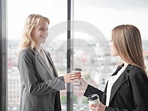 Business woman offering coffee to colleague