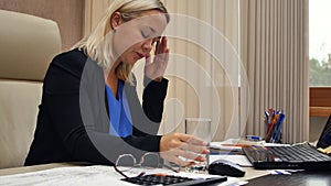 Business woman in the office. Portrait of a woman who suffers from severe headache while working in the office