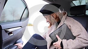 Business woman opens car door and getting out car