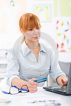 Business woman paying bills with credit card on internet