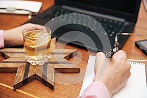 A business woman is planning her day, week, month and records her plans in a notebook. Along with a business notepad on the table