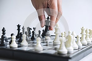 Business woman playing chess and thinking strategy about crash overthrow the opposite team and development analysis for win and