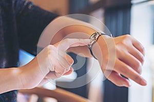 A business woman pointing at a black wristwatch on her working time