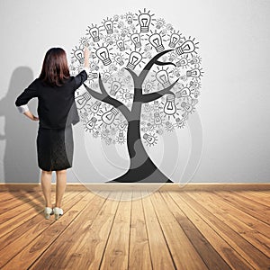 Business woman pointing concept picture of idea tree on wood f