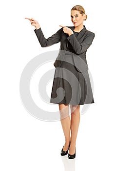 Business woman pointing at copyspace on the left