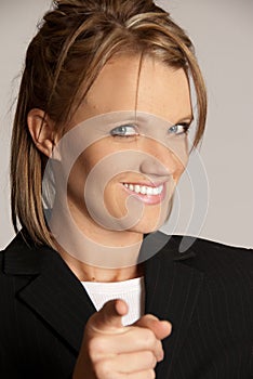 Business woman pointing finger looking at camera